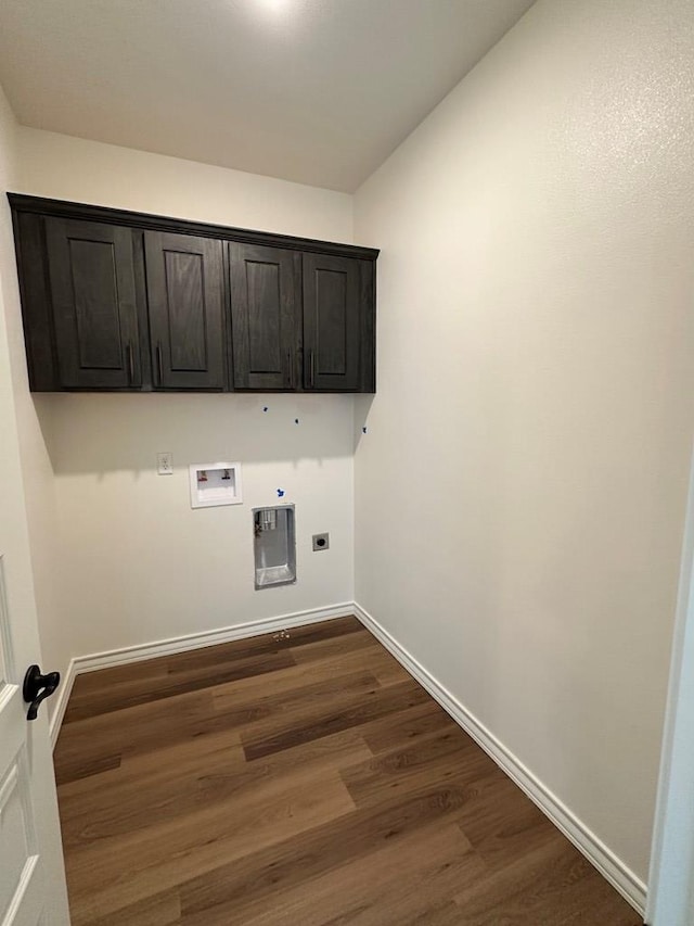 7409 Easton Ave, San Angelo, TX 76904 - laundry area featuring electric dryer hookup, hookup for a washing machine, baseboards, dark wood-type flooring, and cabinet space
