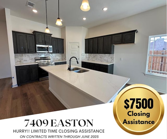 7409 Easton Ave, San Angelo, TX 76904 - kitchen with appliances with stainless steel finishes, a sink, dark cabinetry, dark wood-style flooring, and decorative backsplash