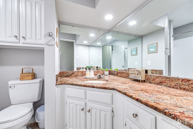 bathroom with vanity, recessed lighting, a shower, and toilet