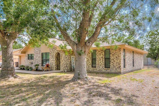 view of front of property with brick siding and fence