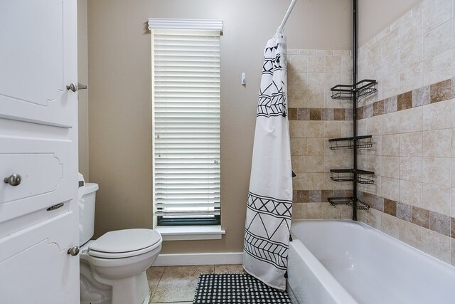 bathroom with baseboards, tile patterned flooring, toilet, and shower / bathtub combination with curtain