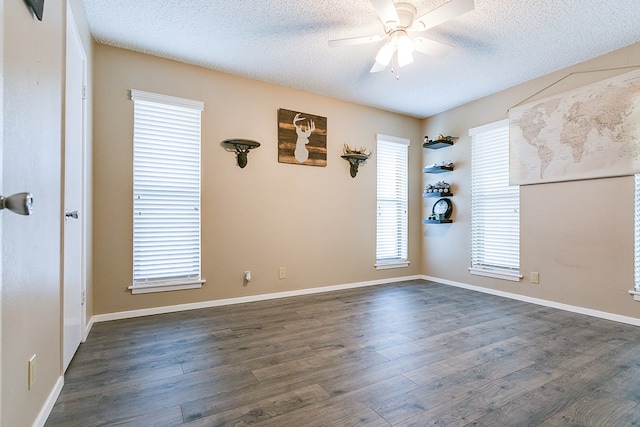 unfurnished room featuring ceiling fan, dark wood-type flooring, and a textured ceiling