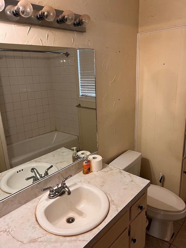 bathroom with vanity, toilet, a bathing tub, and tile patterned flooring