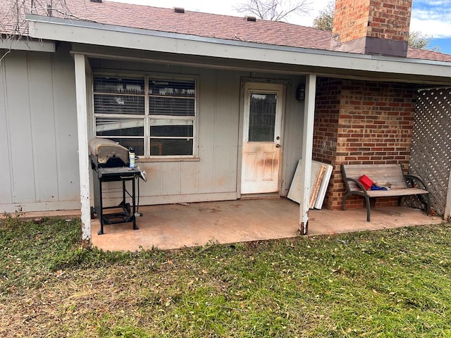 property entrance featuring a patio area and a lawn