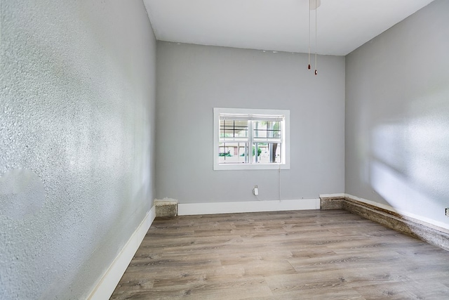 unfurnished room featuring baseboards and wood finished floors