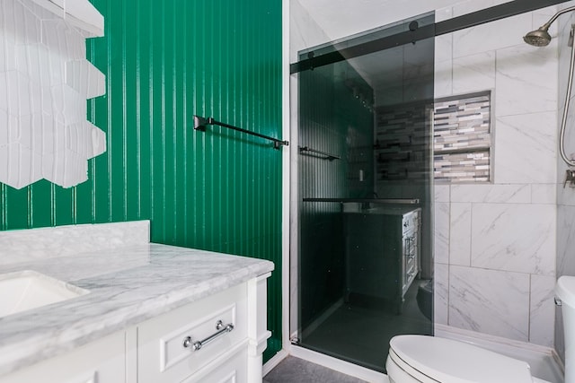 full bathroom featuring toilet, a shower stall, and vanity