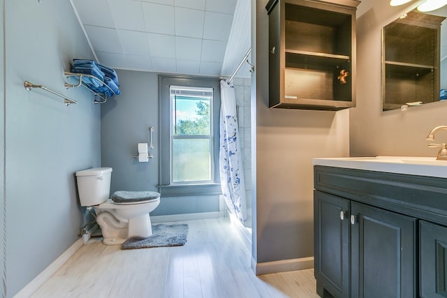 bathroom with hardwood / wood-style flooring, vanity, a shower with curtain, and toilet