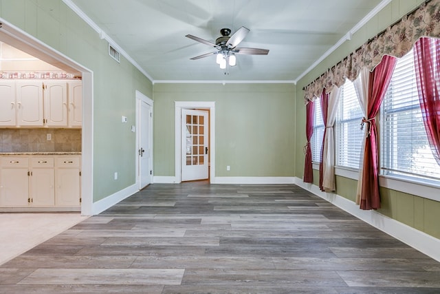 interior space featuring ceiling fan, ornamental molding, and light wood-type flooring