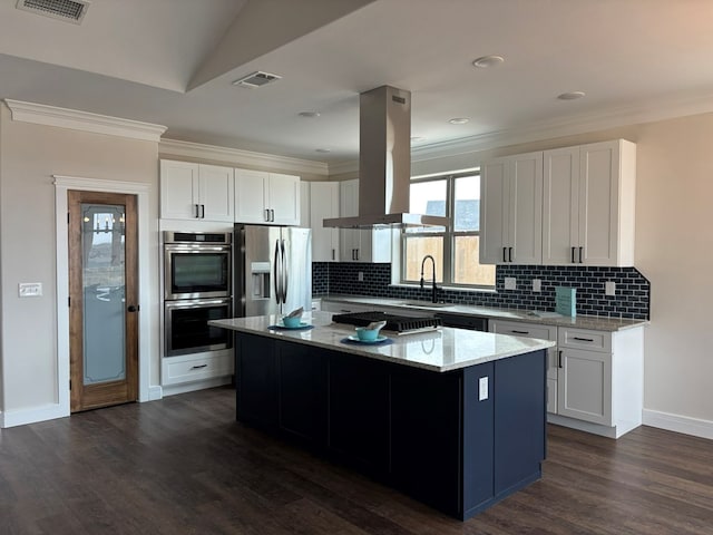 kitchen with light stone counters, visible vents, a kitchen island, appliances with stainless steel finishes, and island range hood