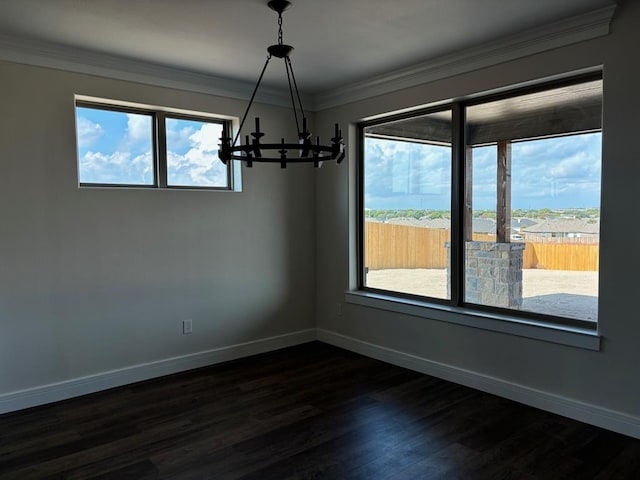 spare room with an inviting chandelier, crown molding, and dark wood-type flooring