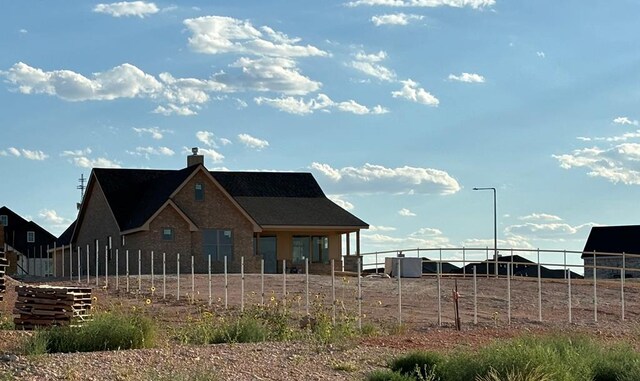 back of house featuring fence and a chimney