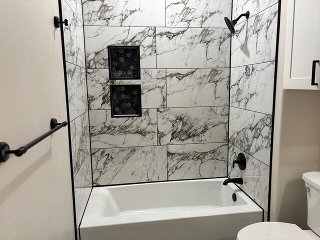 bathroom with toilet and tiled shower / bath combo