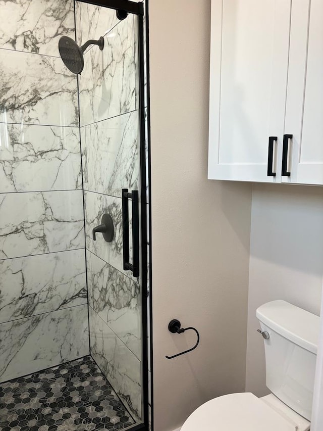 bathroom with a stall shower and toilet