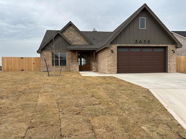 view of front of home with an attached garage, fence, brick siding, and driveway