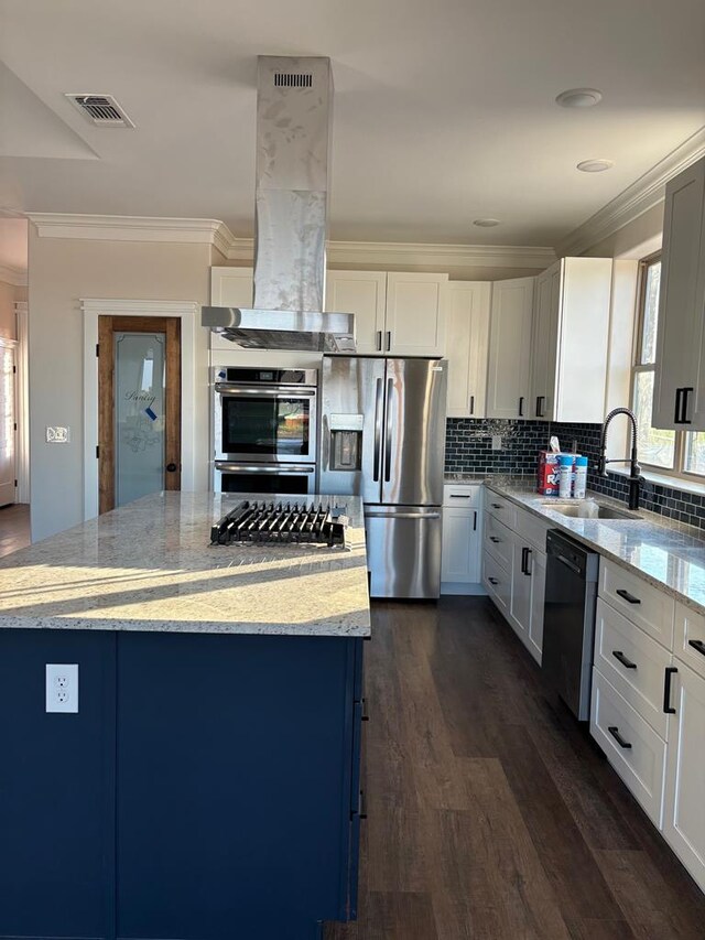 kitchen with light stone counters, island exhaust hood, appliances with stainless steel finishes, and a kitchen island