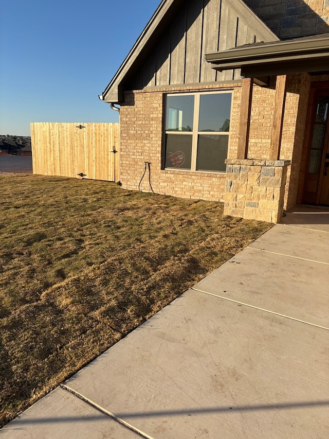 view of home's exterior featuring fence, brick siding, and board and batten siding