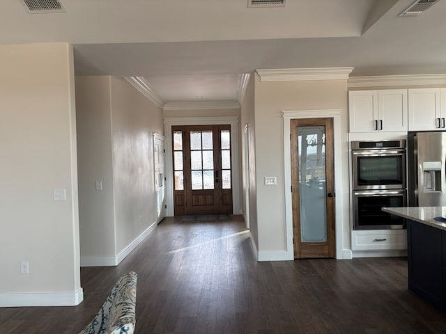 foyer featuring dark wood-style floors, visible vents, and crown molding