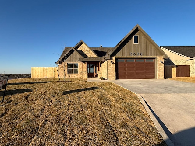 view of front of home with driveway, brick siding, an attached garage, and fence