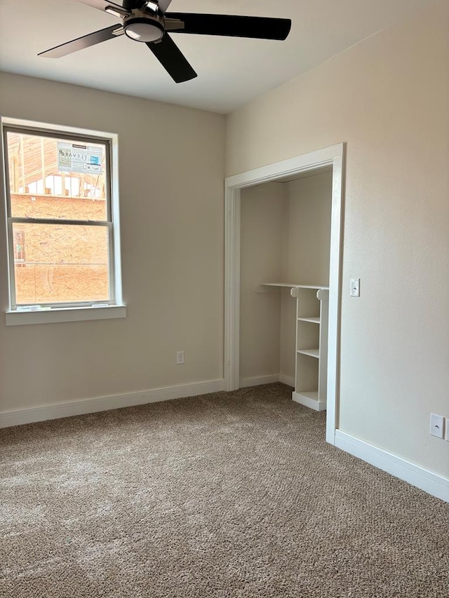 unfurnished bedroom with baseboards, carpet floors, a closet, and a ceiling fan