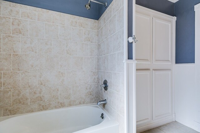 bathroom featuring tiled shower / bath combo and tile patterned flooring