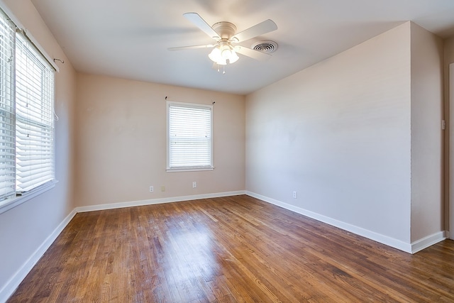 spare room featuring dark wood-type flooring and ceiling fan