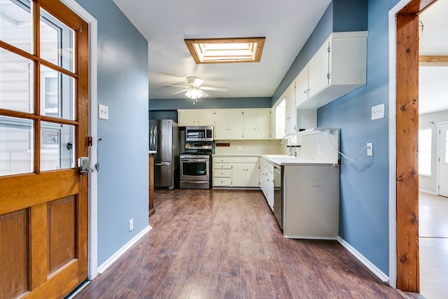 kitchen with sink, dark hardwood / wood-style floors, white cabinets, and appliances with stainless steel finishes