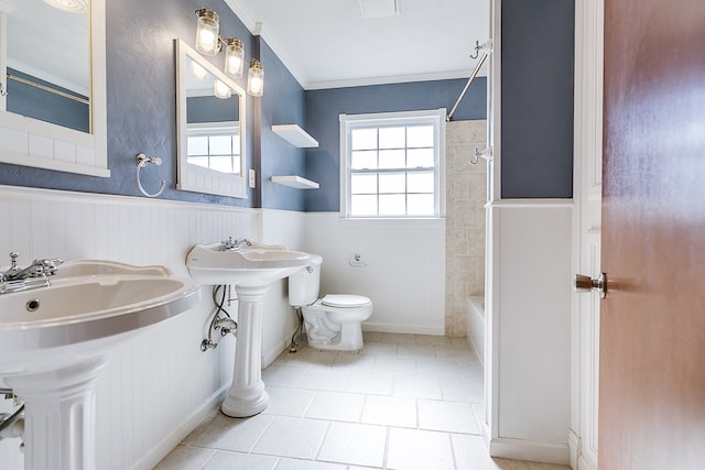 full bathroom featuring tile patterned floors, toilet, sink, ornamental molding, and tiled shower / bath combo