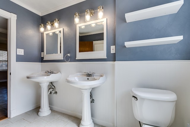 bathroom with crown molding, dual sinks, tile patterned floors, and toilet