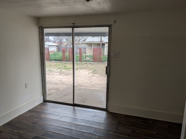 doorway featuring dark hardwood / wood-style flooring and a textured ceiling