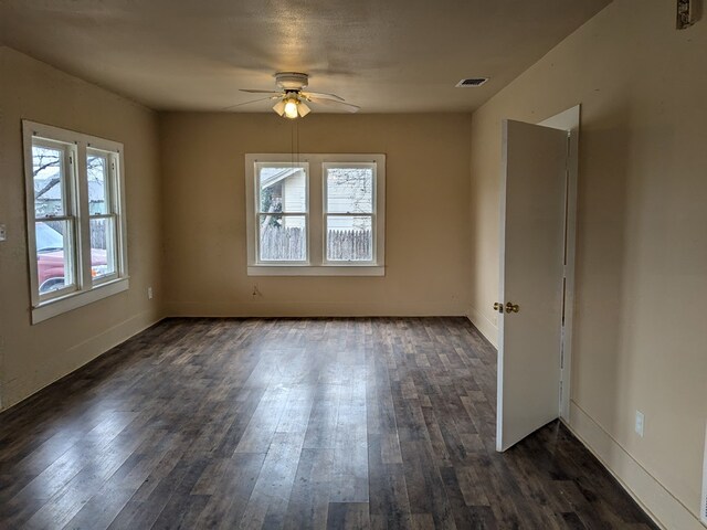 spare room with plenty of natural light, dark hardwood / wood-style floors, and ceiling fan