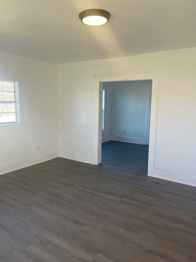 unfurnished room with dark wood-type flooring