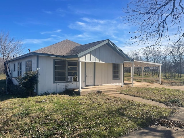 view of front facade featuring a front yard, a carport, and covered porch