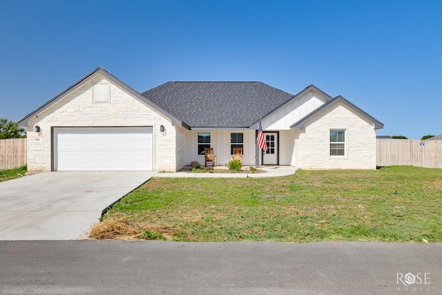 2846 Ricks Dr, San Angelo, TX 76905 - view of front of house featuring stone siding, a garage, board and batten siding, and driveway