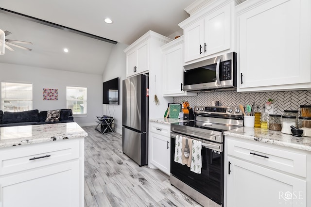 2846 Ricks Dr, San Angelo, TX 76905 - kitchen with stainless steel appliances, vaulted ceiling, ceiling fan, tasteful backsplash, and white cabinetry