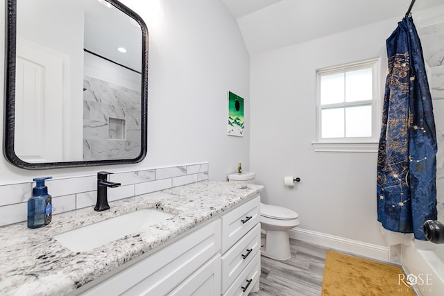 2846 Ricks Dr, San Angelo, TX 76905 - full bath with vanity, a shower with curtain, lofted ceiling, wood finished floors, and backsplash