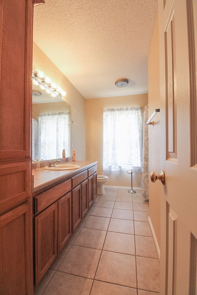 5905 Stratford Ave, San Angelo, TX 76901 - full bathroom with vanity, a textured ceiling, tile patterned flooring, and toilet