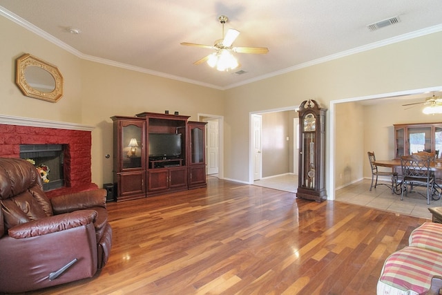 5905 Stratford Ave, San Angelo, TX 76901 - living area with ceiling fan, ornamental molding, a brick fireplace, and wood finished floors