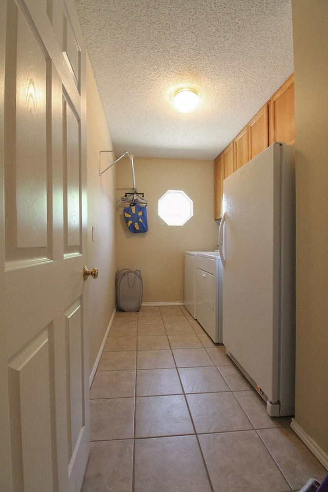 5905 Stratford Ave, San Angelo, TX 76901 - laundry room featuring cabinet space, a textured ceiling, baseboards, light tile patterned floors, and washer and clothes dryer