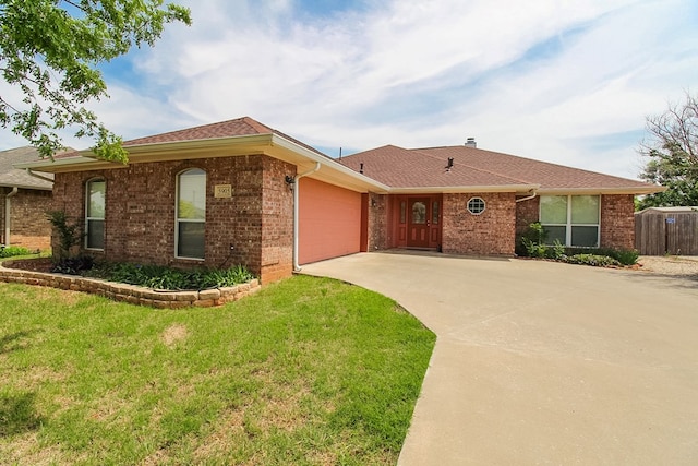 5905 Stratford Ave, San Angelo, TX 76901 - ranch-style home featuring a front lawn, fence, brick siding, concrete driveway, and an attached garage