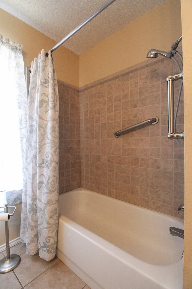 5905 Stratford Ave, San Angelo, TX 76901 - full bathroom featuring a textured ceiling, tile patterned floors, and shower / bath combination with curtain