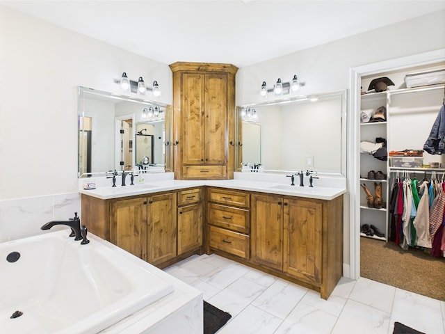 8353 Chad Rd, San Angelo, TX 76957 - bathroom featuring double vanity, marble finish floors, a bath, and a walk in closet