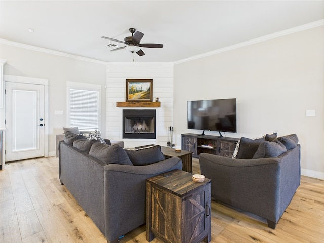 8353 Chad Rd, San Angelo, TX 76957 - living room with a ceiling fan, light wood-style flooring, crown molding, a fireplace, and baseboards