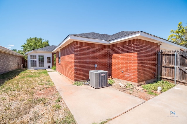 view of property exterior with cooling unit and a patio