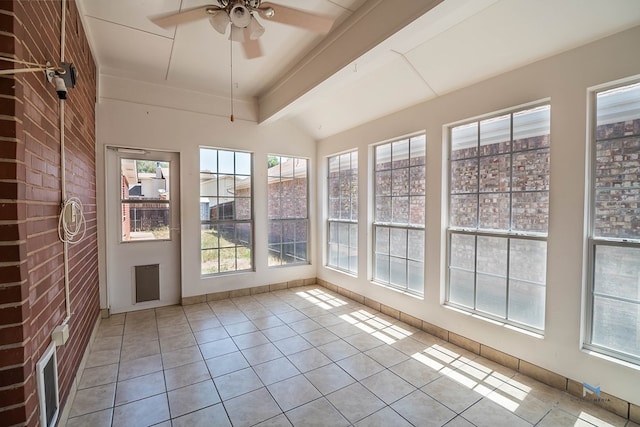 unfurnished sunroom featuring ceiling fan, lofted ceiling with beams, and a wealth of natural light