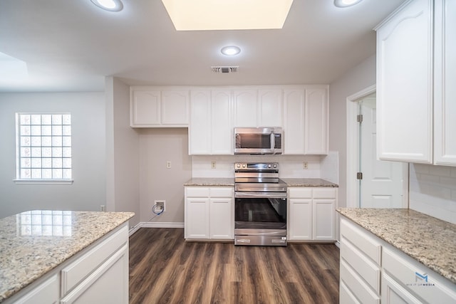 kitchen with light stone counters, backsplash, white cabinets, and appliances with stainless steel finishes