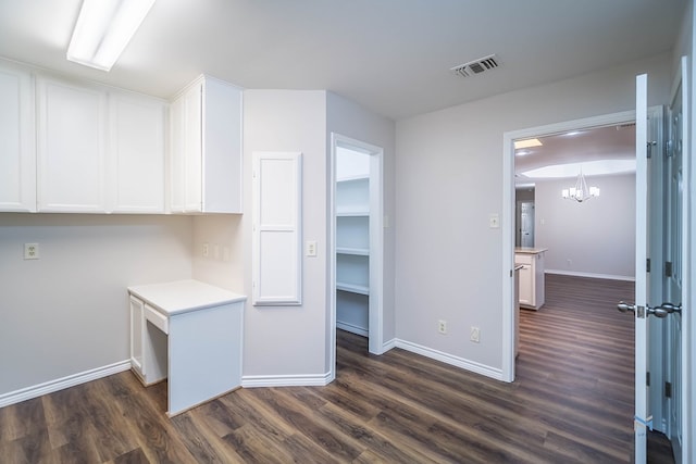 kitchen with white cabinetry, dark hardwood / wood-style flooring, and an inviting chandelier