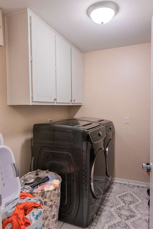 washroom with cabinets and washing machine and dryer