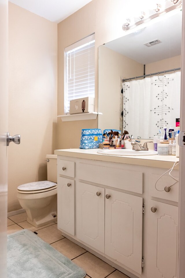 bathroom with tile patterned flooring, vanity, and toilet