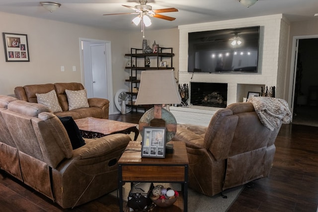 living room featuring dark wood-type flooring, ceiling fan, and a fireplace