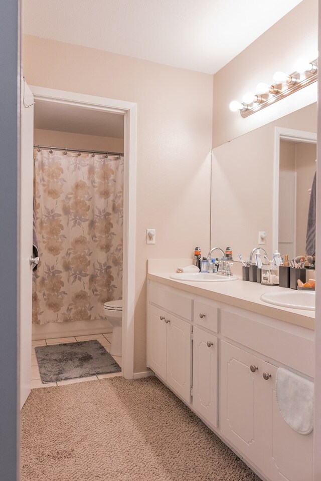 bathroom with vanity, tile patterned flooring, toilet, and walk in shower